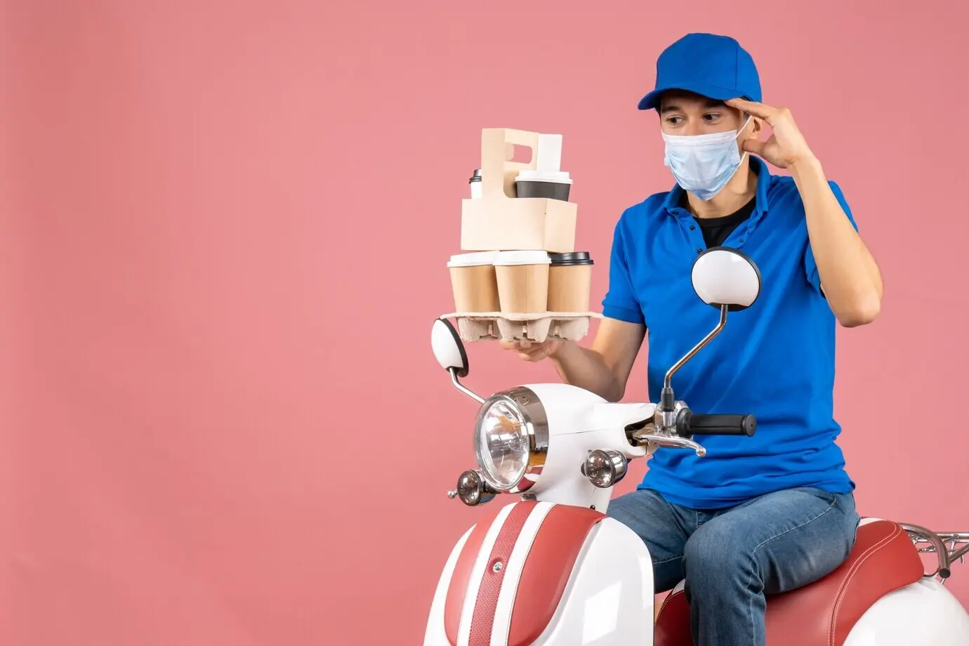 Вид сверху: удивлённый курьер-мужчина в маске и головном уборе, сидящий на скутере и доставляющий заказы, на персиковом фоне.